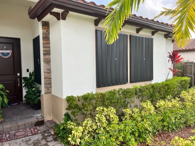 Black accordion shutters installed on a front elevation